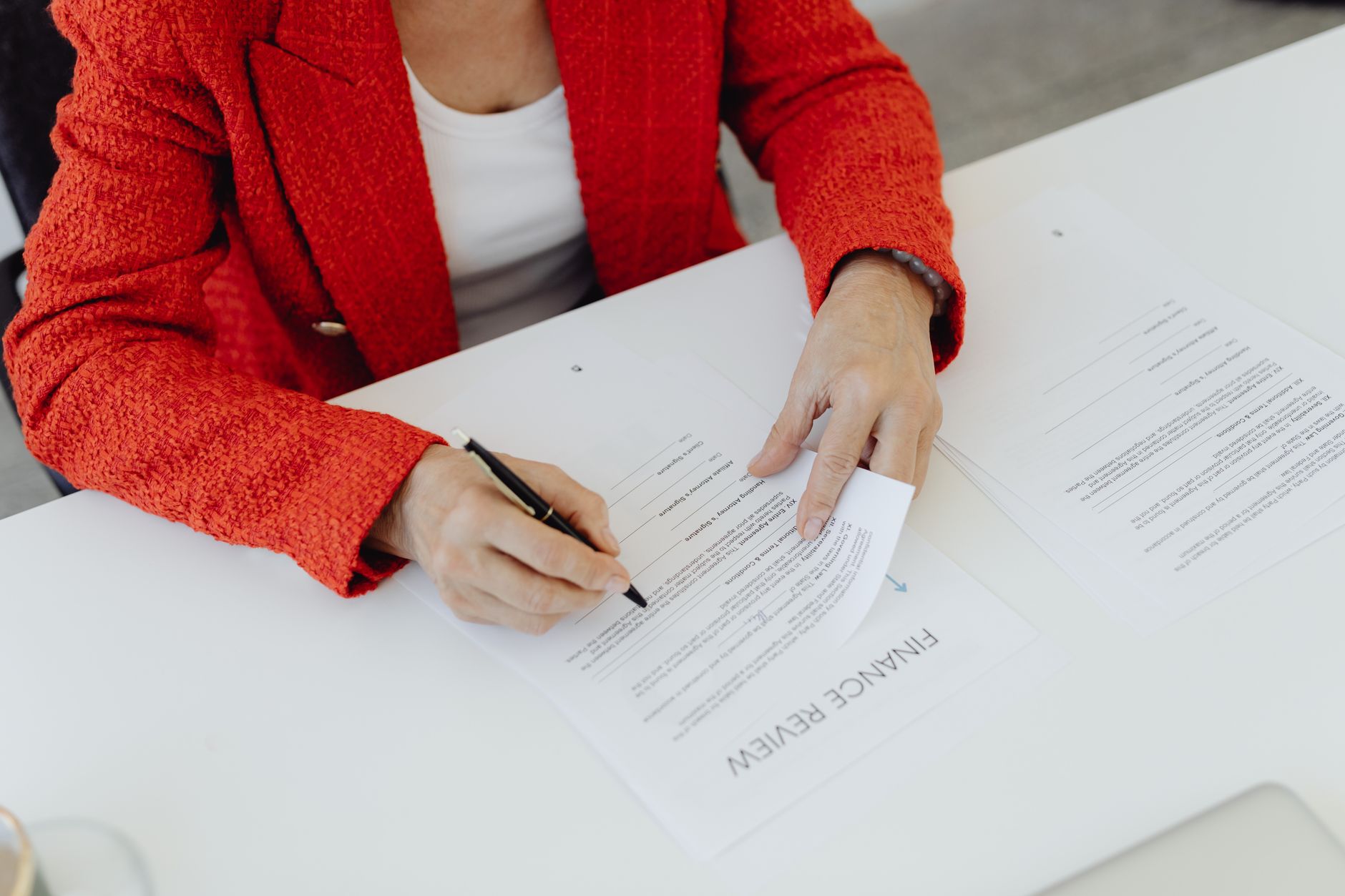 Signed company papers, a pen and a stamp on an office desk