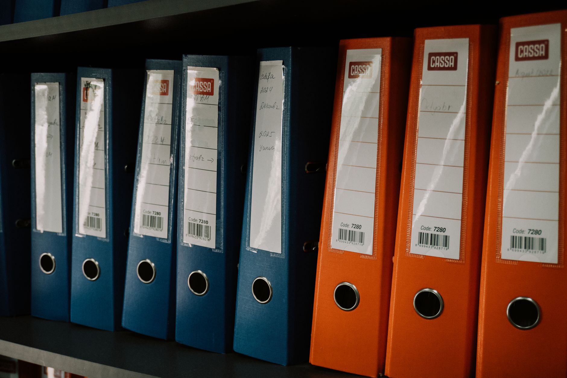 Archive boxes and labelled document folders on an office shelf