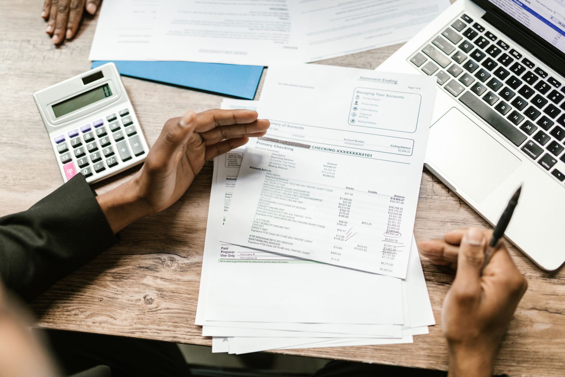 Tax documents and a calculator on an office desk, seen from above.