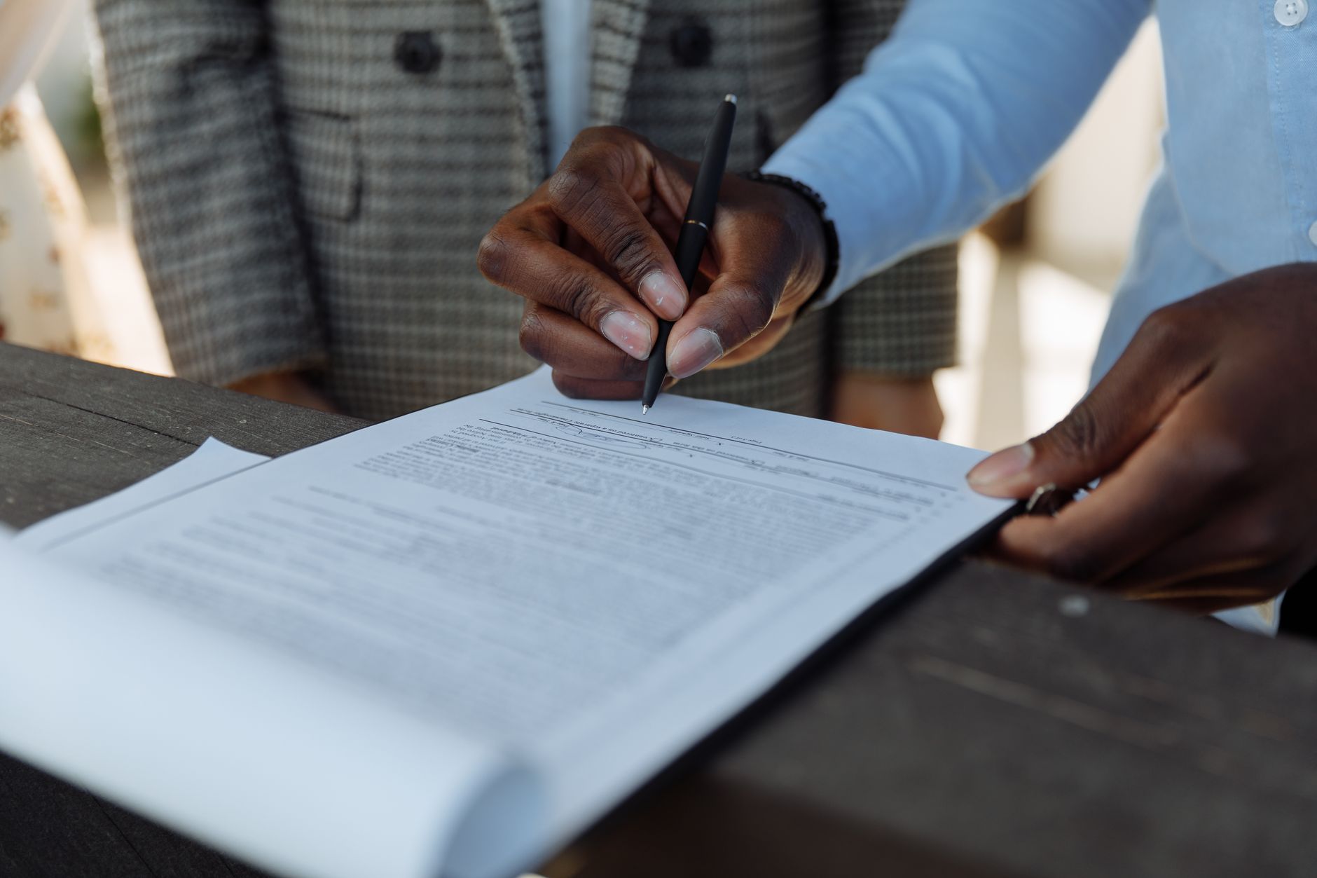 A folder of business documents and a pen on a desk.