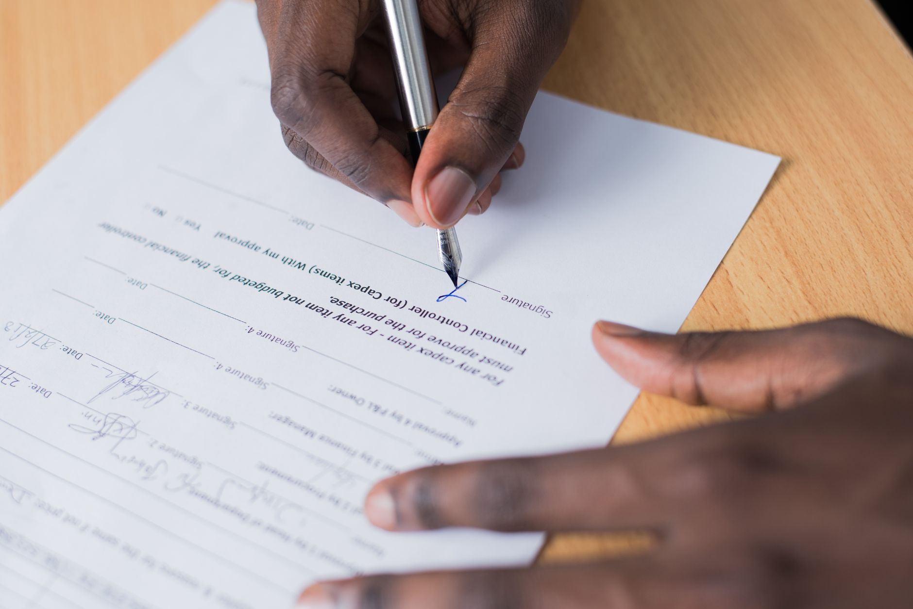 A signed agreement and a pen on an office desk