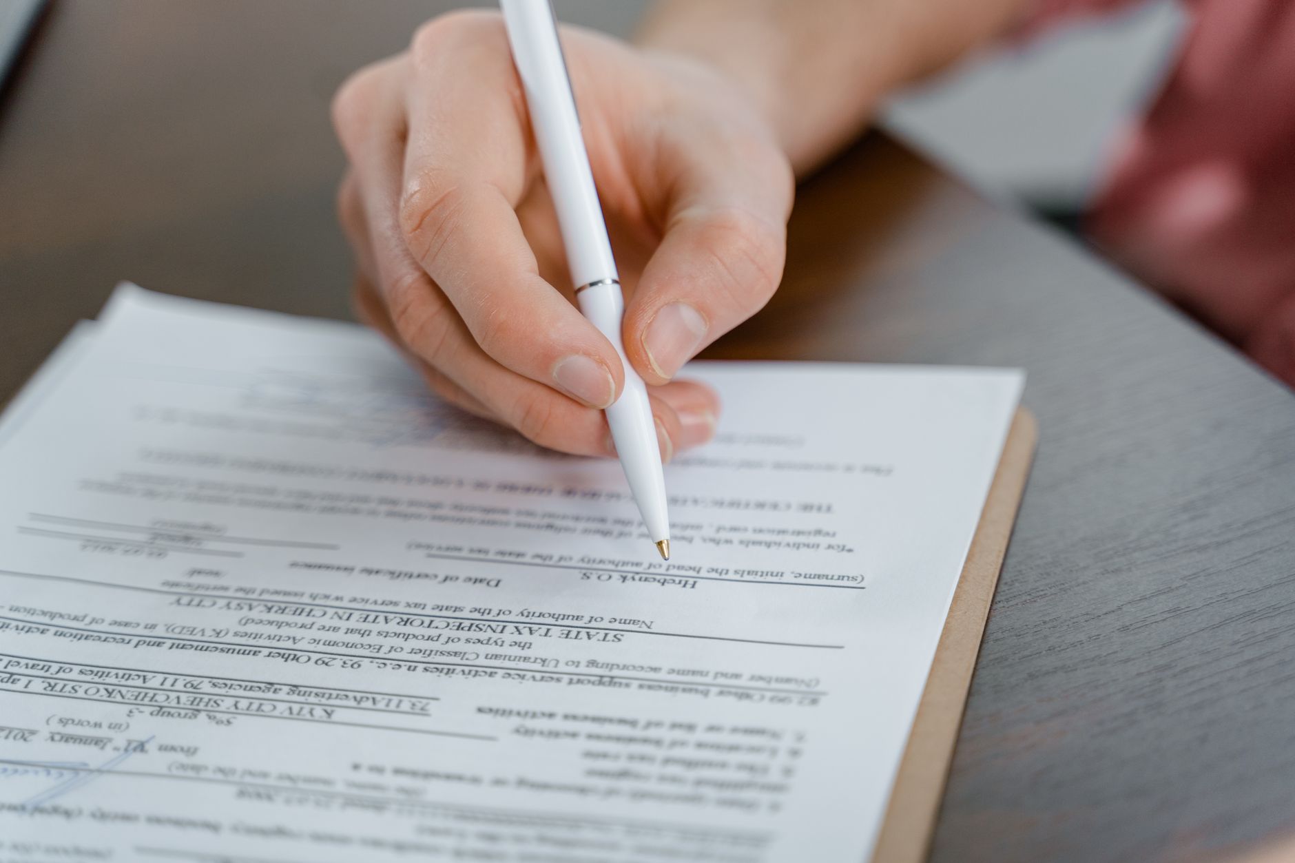 A signed company document and a pen on a desk
