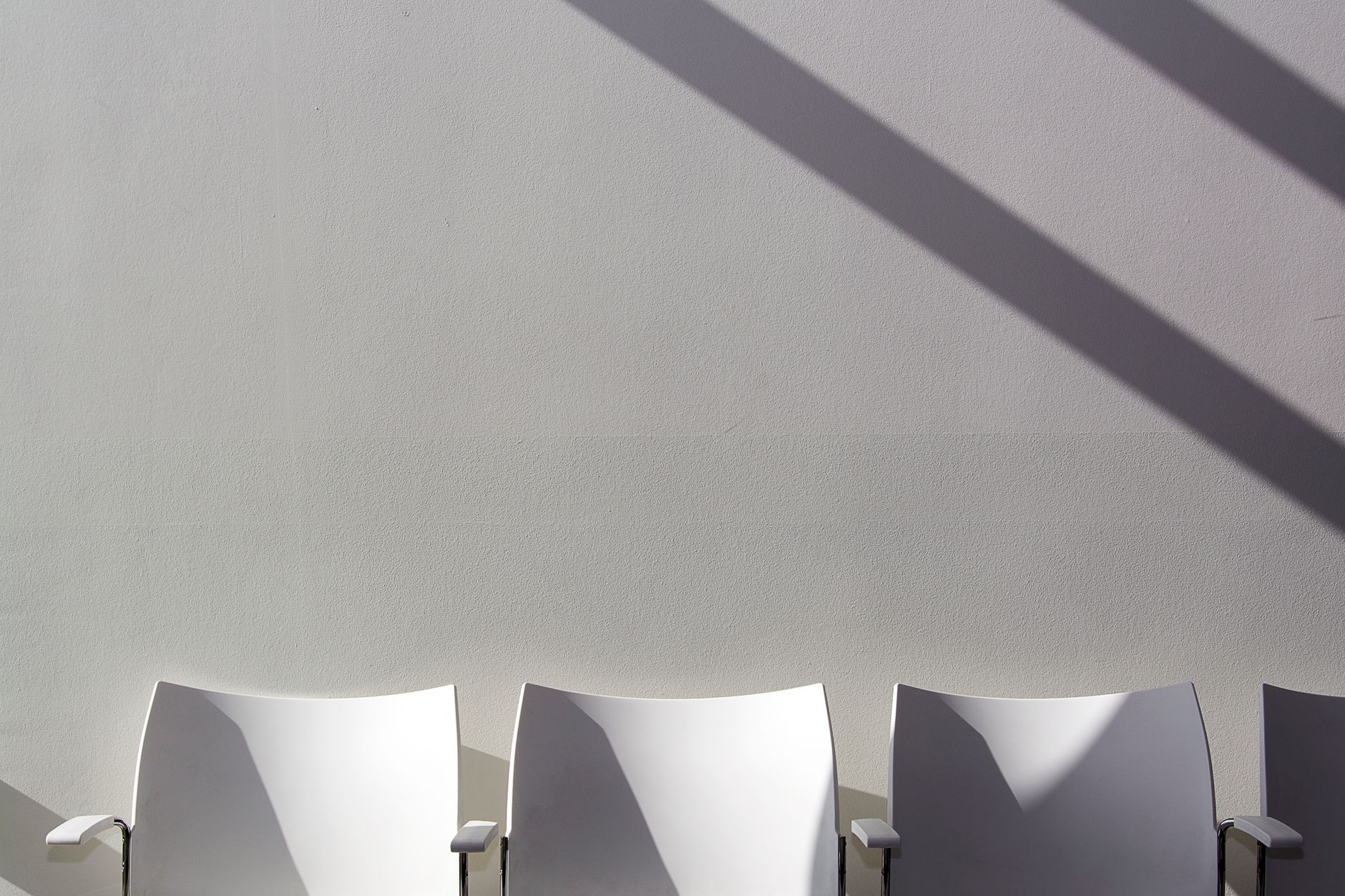 An empty meeting room with a long table and chairs in daylight.